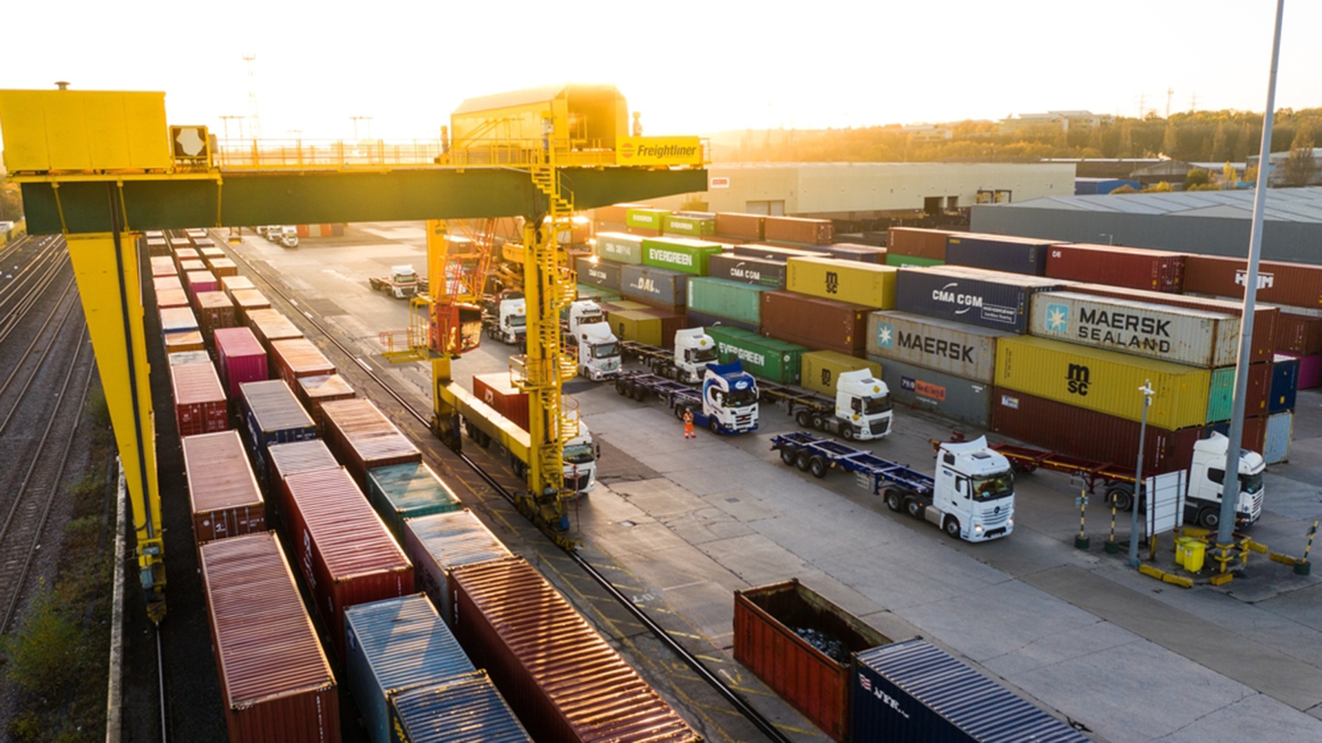 LEEDS, UK - NOVEMBER 22, 2021.  Aerial view of a busy shipping container rail terminal in Leeds with shipping boxes waiting to be loaded onto road and reail transport